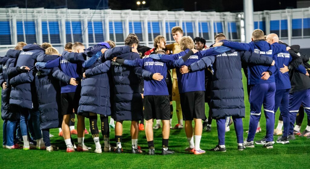 Piłkarze Unii Tarnów w kręgu przed meczem. 23 października 2026.