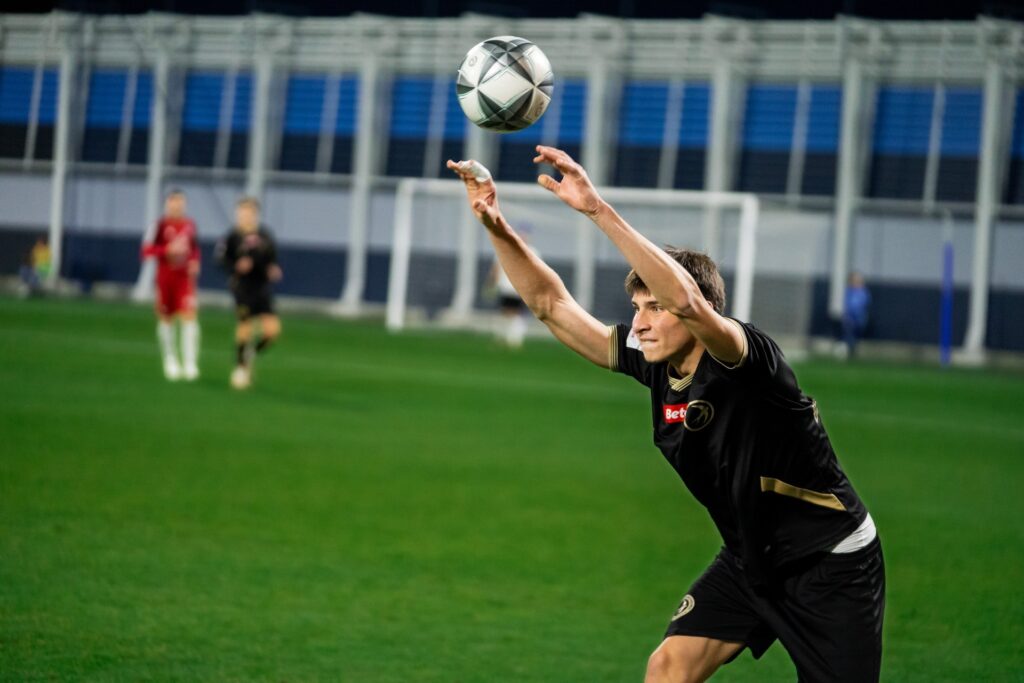 Zawodnik Unii wykonuje wrzut z autu. 23 października 2026.