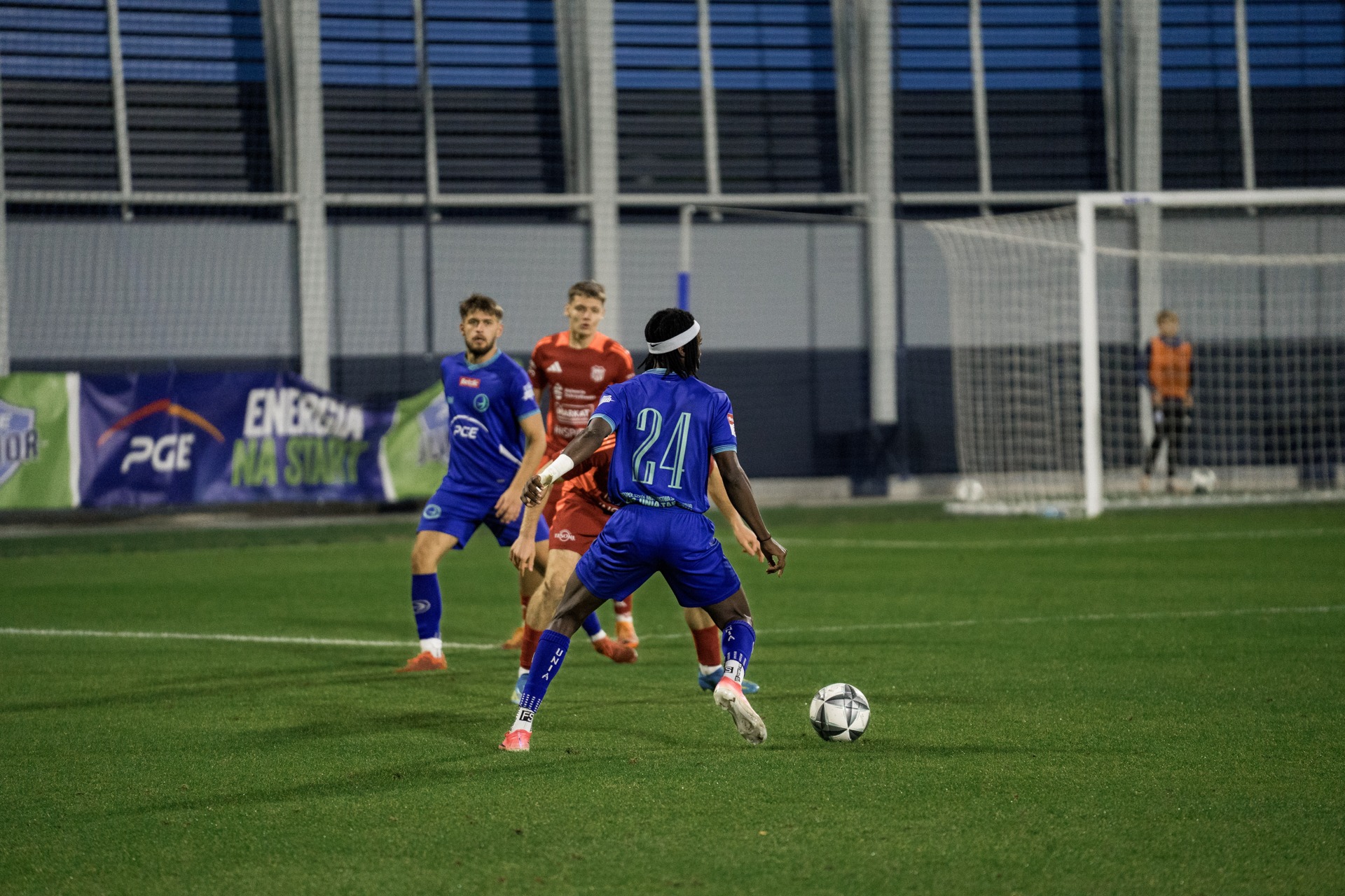Zawodnik Unii Tarnów w niebieskim stroju rozgrywa piłkę podczas meczu z Kalwarianką, 9 października 2026.